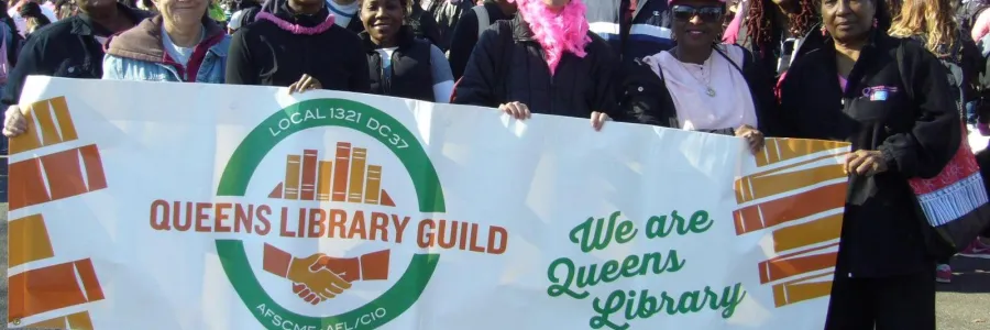 photo of Local 1321 members holding a sign with Queens Library Guild and We Are Queens Library written on it